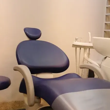 a dentist chair in a room with a painting on the wall